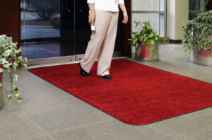 baltimore washington mat service a woman walks on a red entrance mat